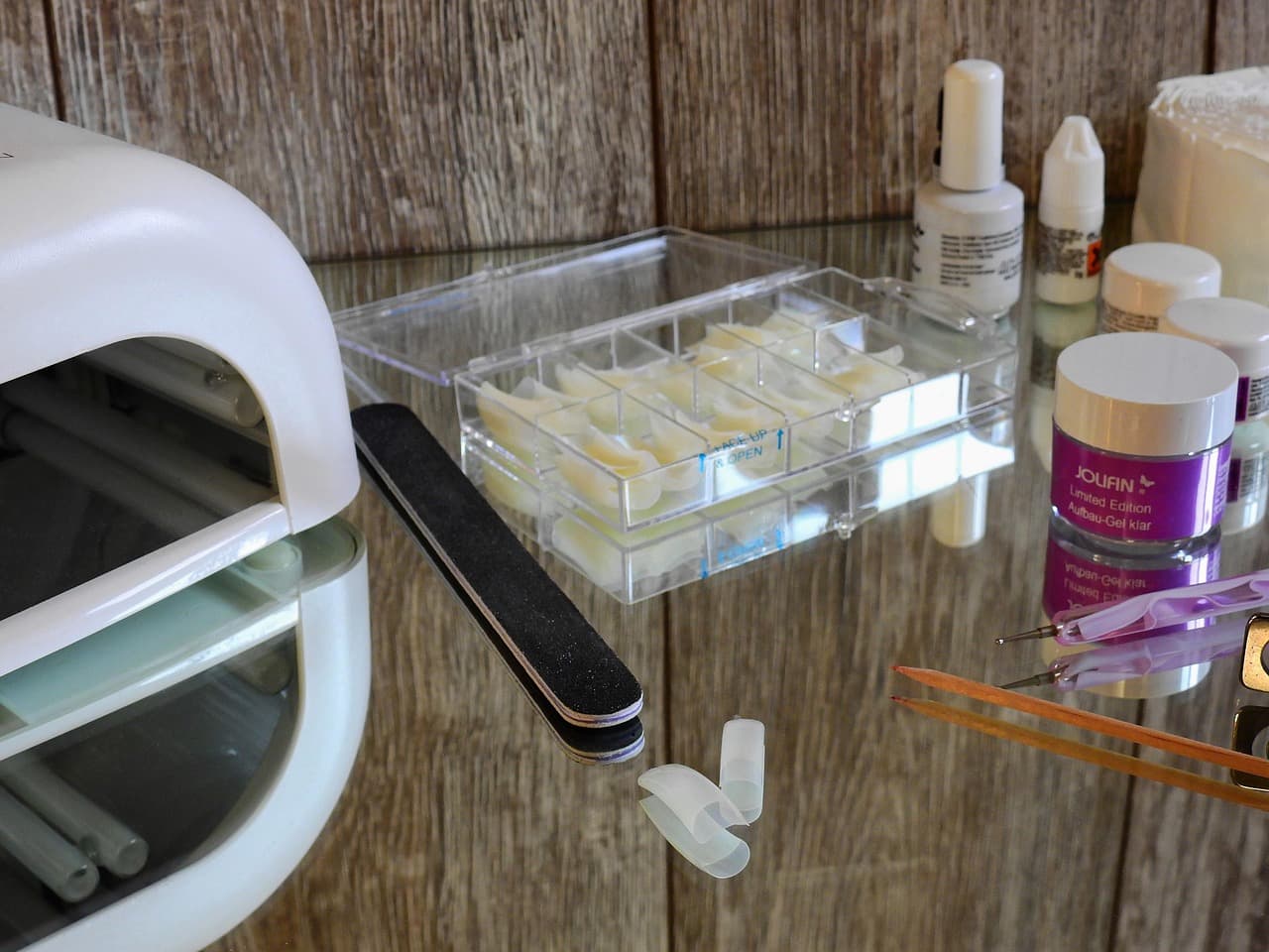 UV lamp, nail tips and polishes on a salon desk