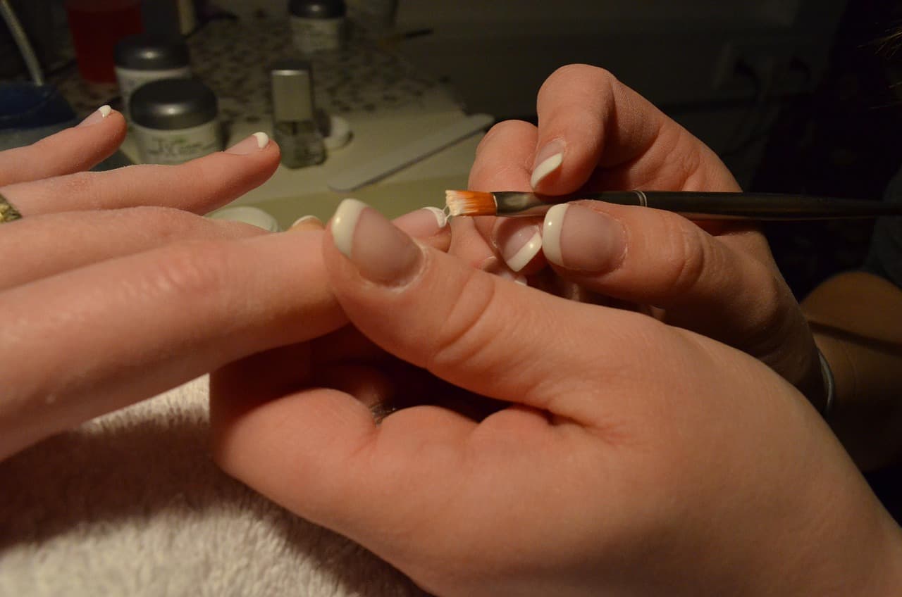 Nail technician painting French tips