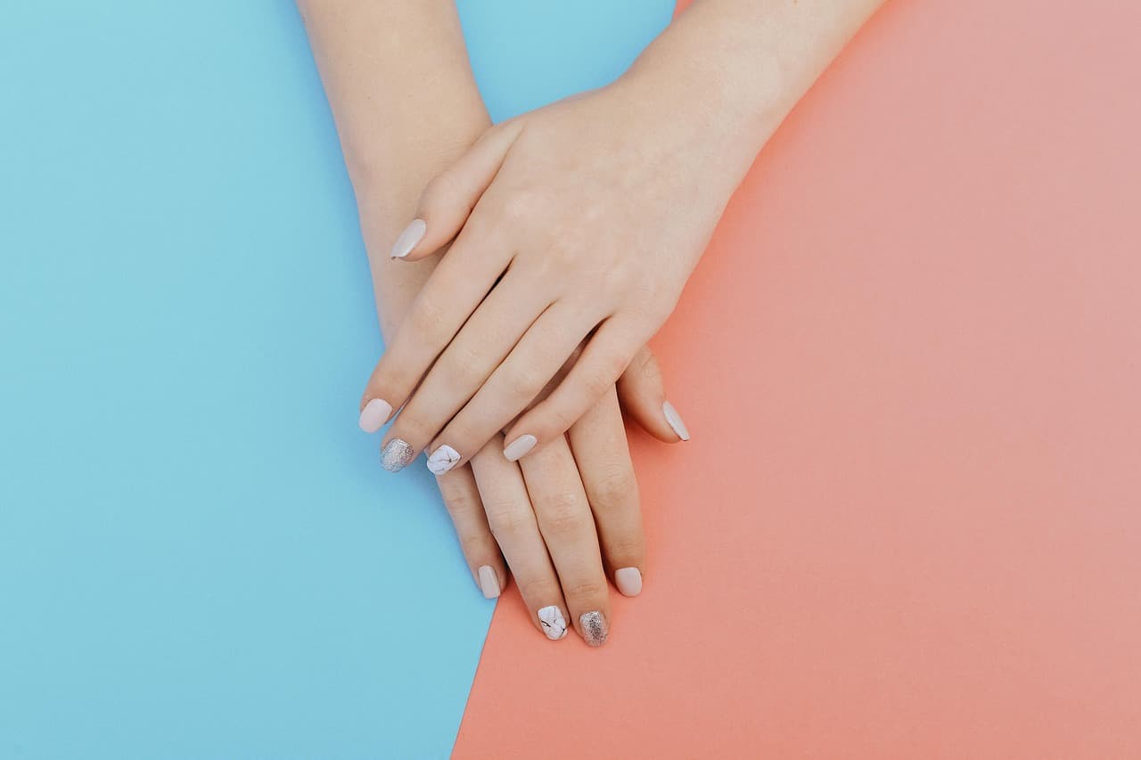 Soft French nails on a blue and coral background